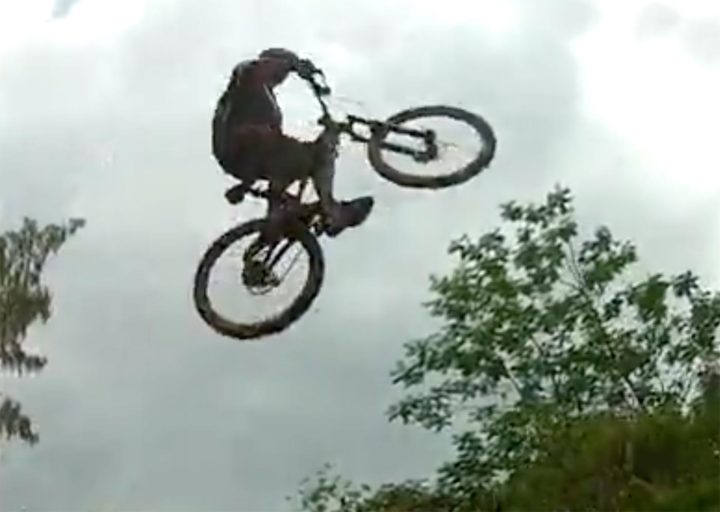 still photo from video: trail cyclist getting big air on a jump