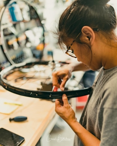 photo: Gen Balladares building a custom bicycle wheel