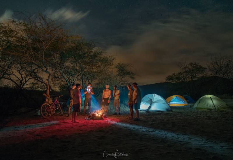 photo: nighttime campsite, tents illuminated from within. Bicycling tours in Hawaii.